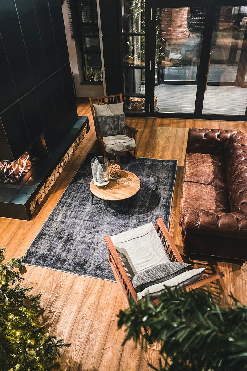 Sala de estar com sofá de couro, tapete e piso de madeira